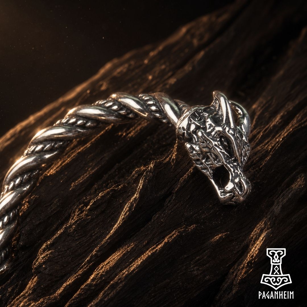 Stainless steel bangle with dragon‑head design resting on wooden surface