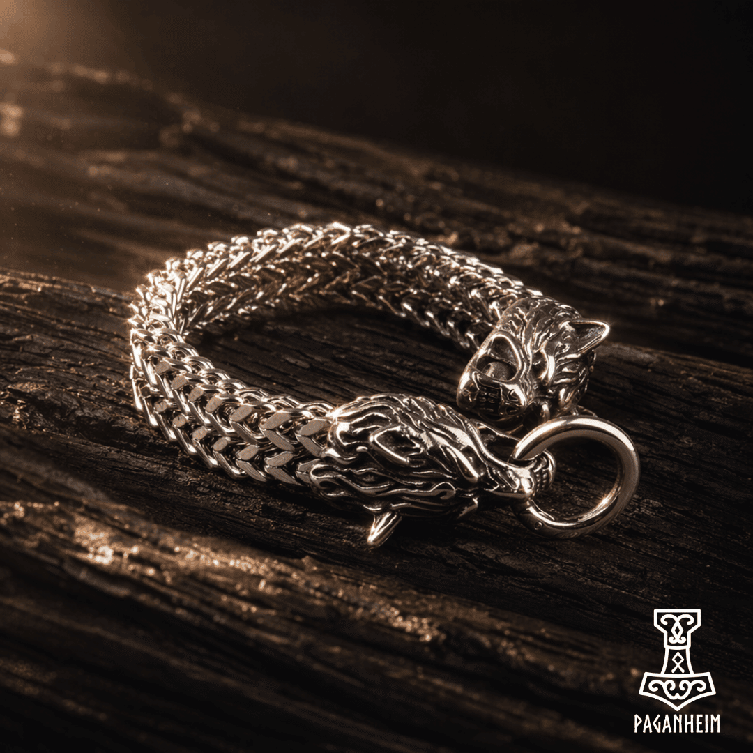 Polished steel wolf bracelet resting on textured wooden surface