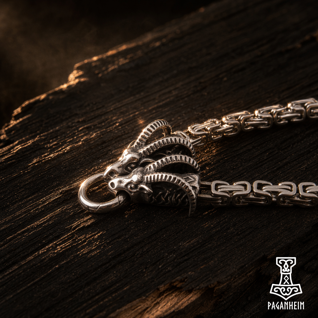 Silver chain with Thor's goats pendant on a dark wooden surface, featuring the Paganheim logo.