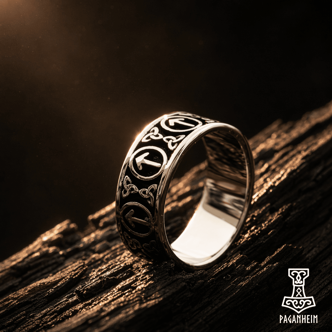 Silver ring with Germanic and Celtic designs on a wooden surface, featuring the brand 'Paganheim'.