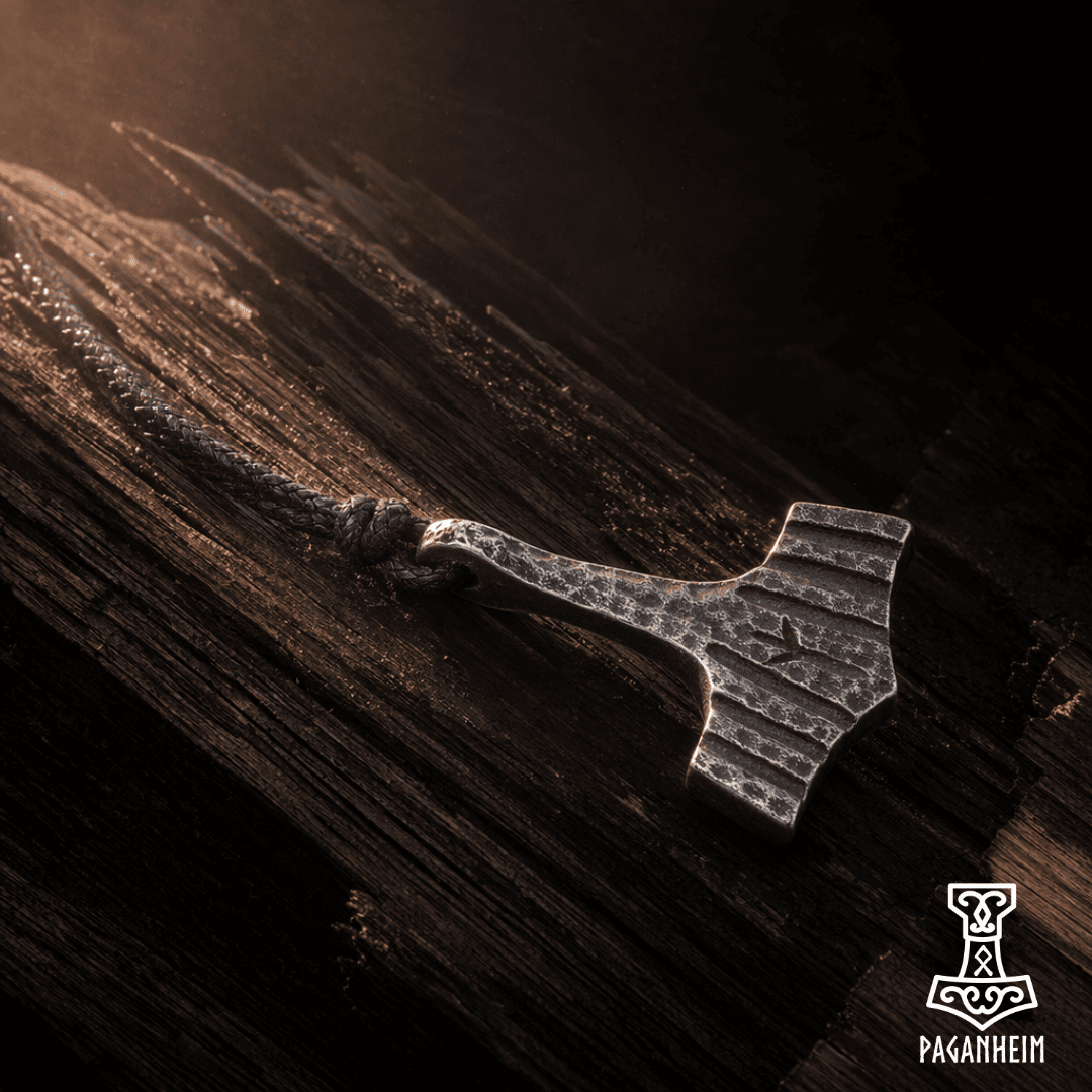 Rune-engraved mjolnir amulet photographed in soft brown lighting