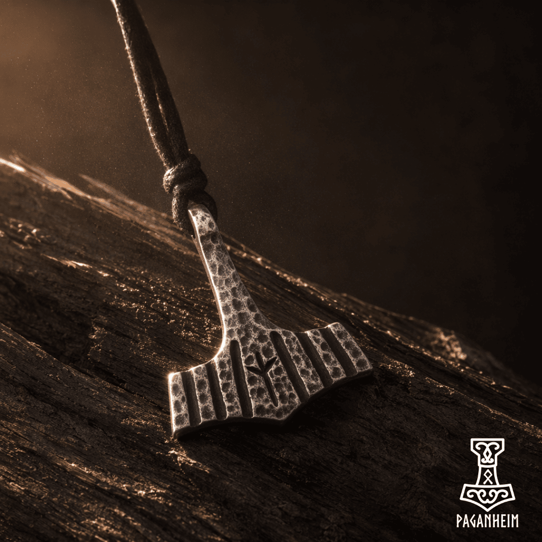 Textured Mjölnir amulet with Algiz rune engraving under warm light
