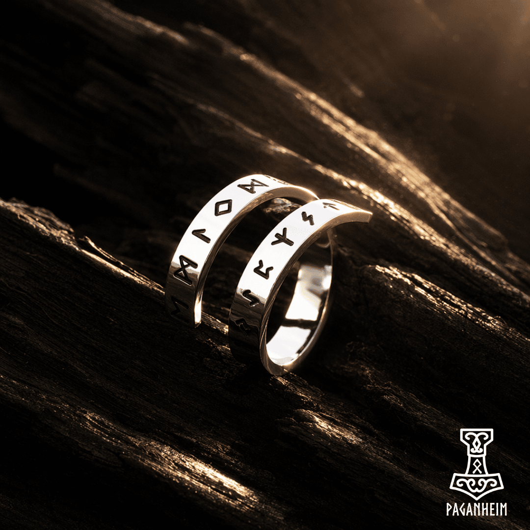 Silver ring featuring engraved Norse runes around the band
