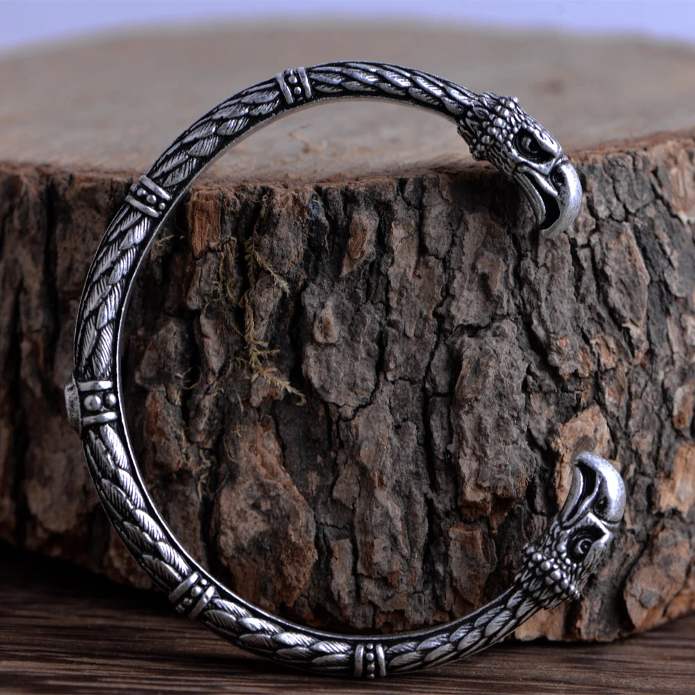 Bangle with raven feather engravings and raven heads on each en