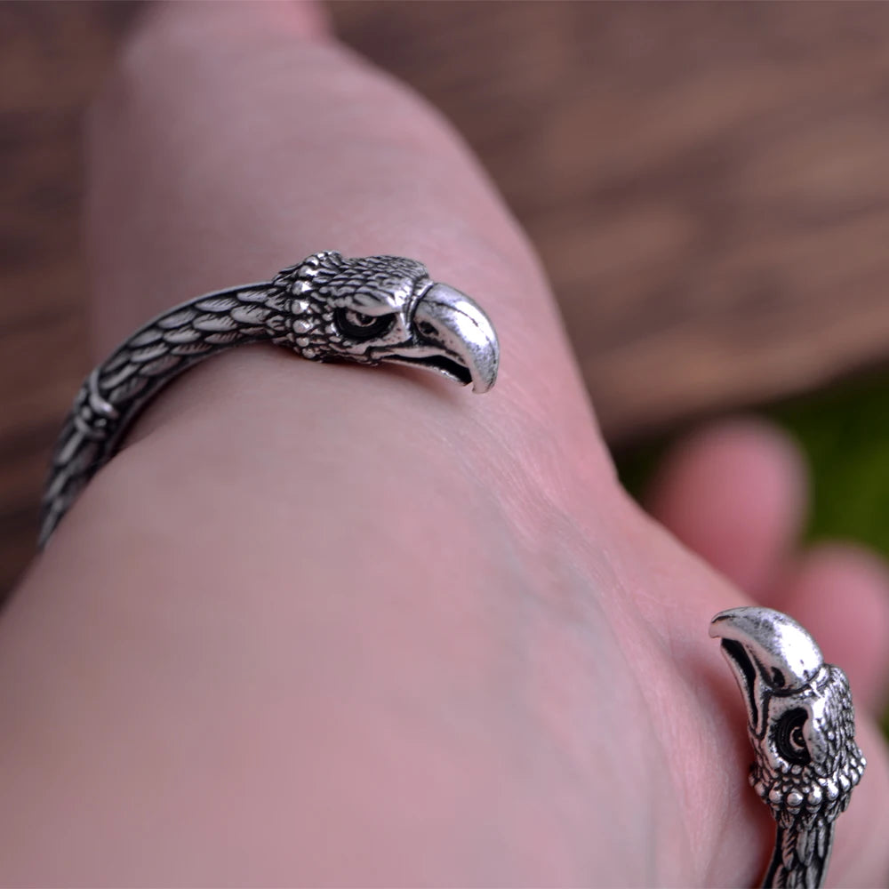 Norse cuff bracelet adorned with raven feather and head motifs.