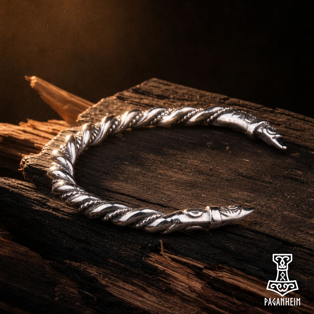 Norse raven arm ring resting on wooden surface under warm light