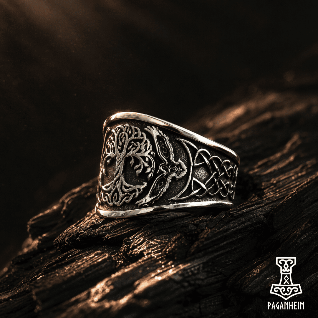 Engraved Yggdrasil and eagle symbols on wide metal band displayed on wood