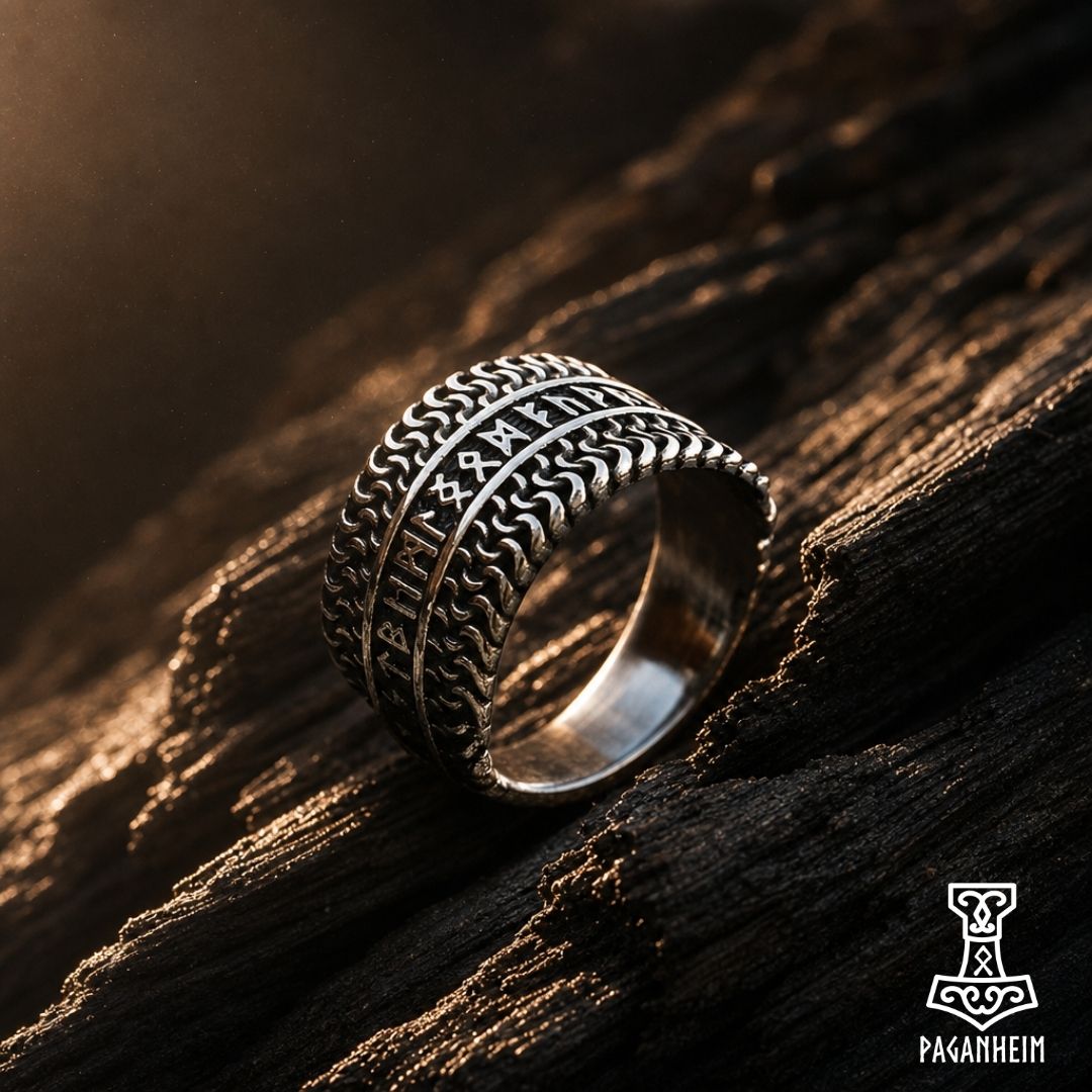 Elder Futhark ring resting on dark wood surface with aged finish