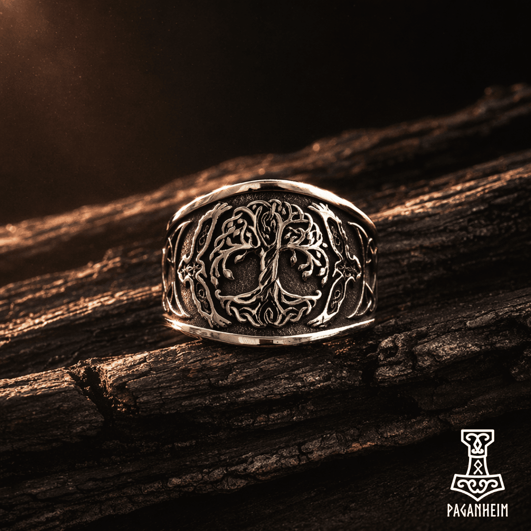 Metal ring with detailed Yggdrasil engraving photographed under warm light