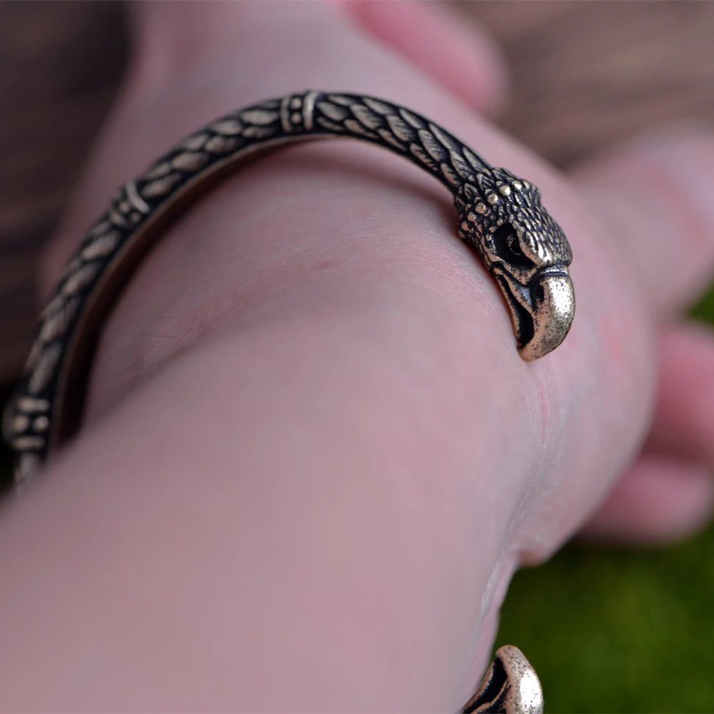 Engraved Norse arm ring with raven feathers and heads at each end.