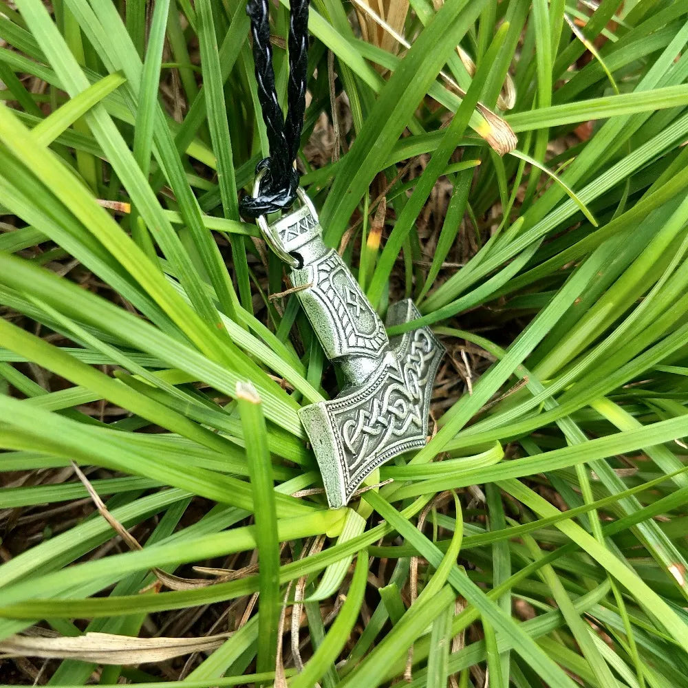 Silver pendant of Thor’s hammer engraved with the Othala rune symbol.