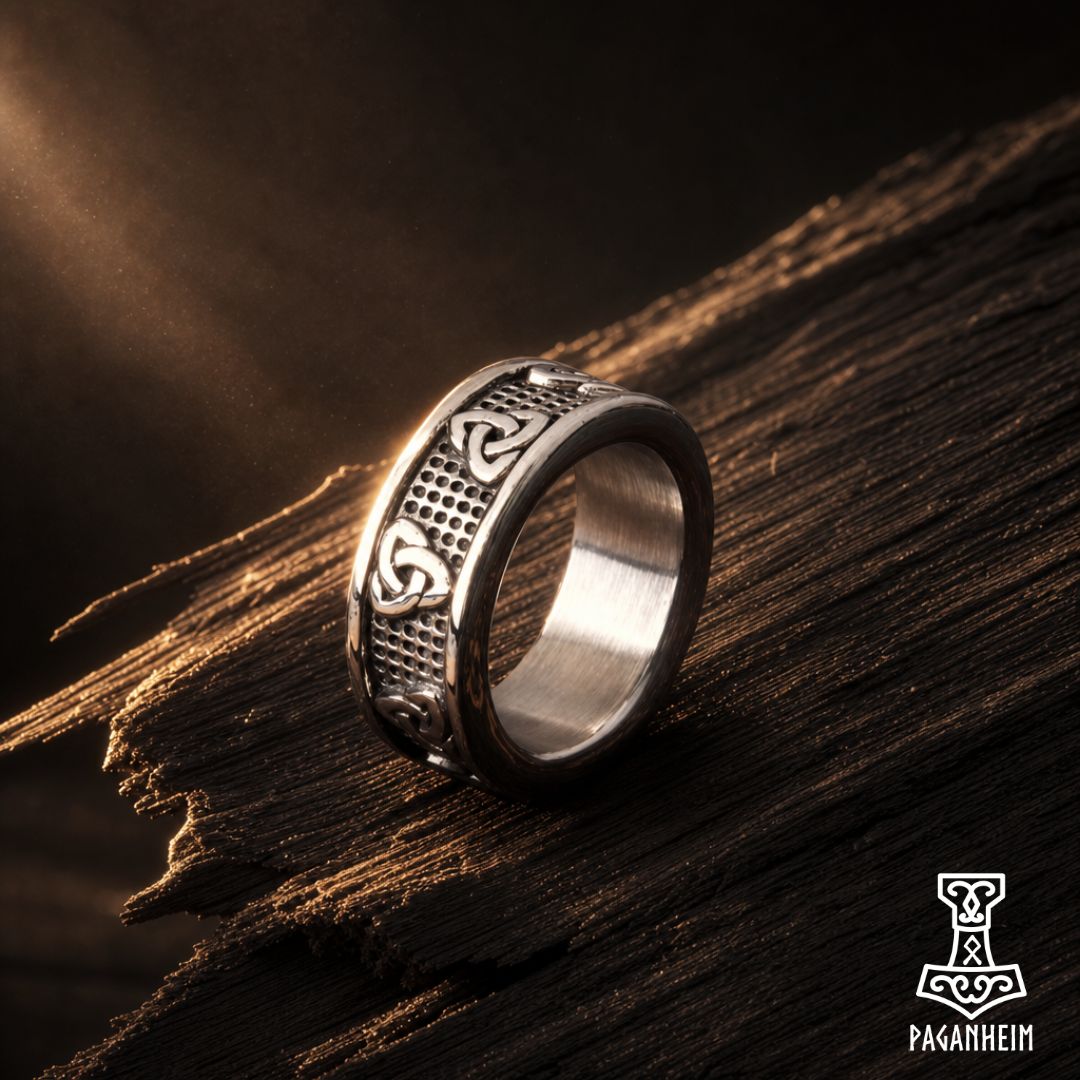 Silver ring featuring engraved Triquetra symbols on textured band.