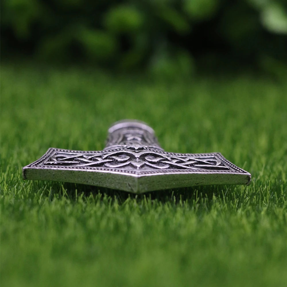 Silver Mjölnir pendant with Othala rune representing Viking heritage.