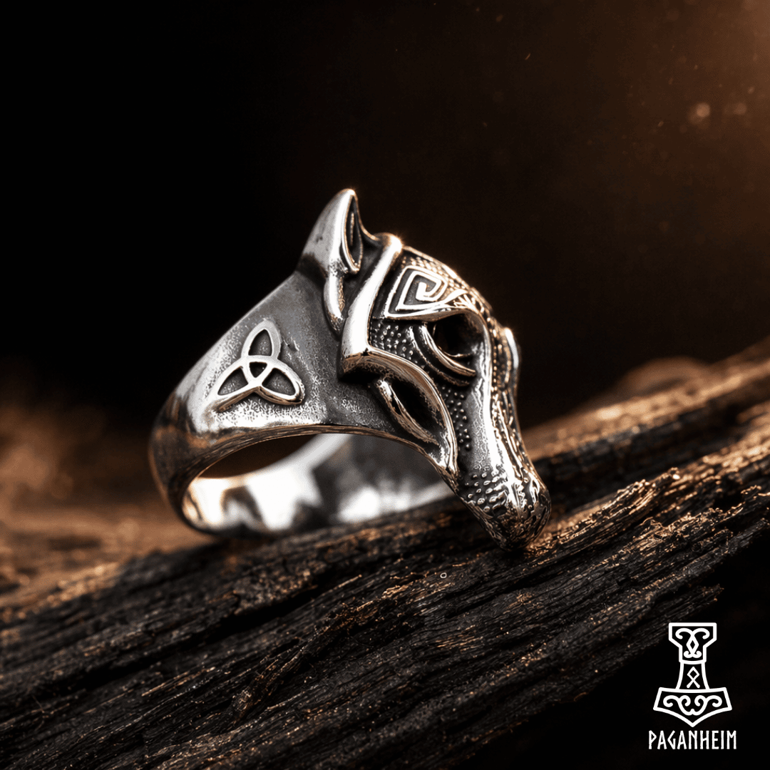 Closeup of Fenrir‑inspired wolf ring resting on dark wood