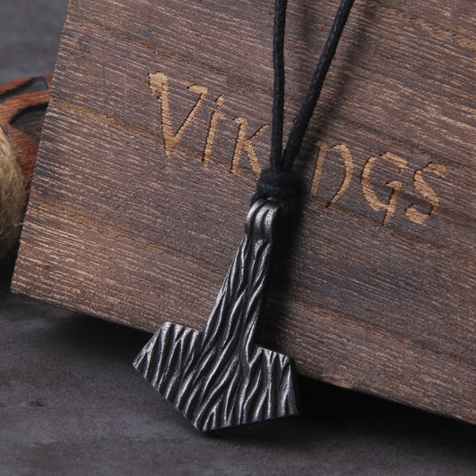 Close-up visual capturing the intricate wind-grooved patterns of the Vindr Mjolnir pendant, complemented by an adjustable waxed cotton necklace - an ideal choice for those seeking adjustable Norse-inspired jewelry.