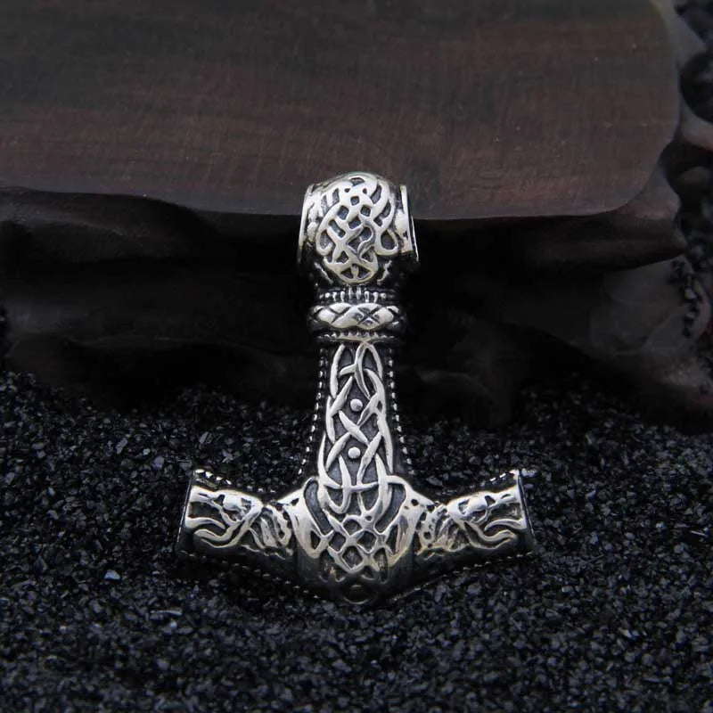 Norse Mjölnir pendant engraved with Jelling and Urnes art styles, showcasing intricate beast motifs.