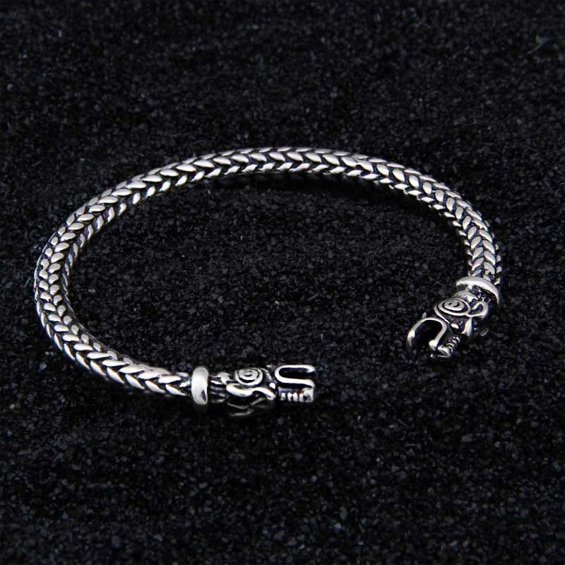 Viking-style sterling silver arm ring featuring a plaited rod design and bear motifs.