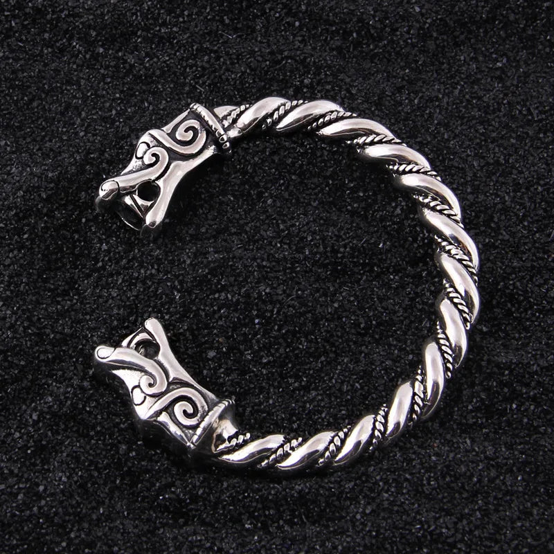 Norse-inspired silver arm ring with dragon heads and rod styling.