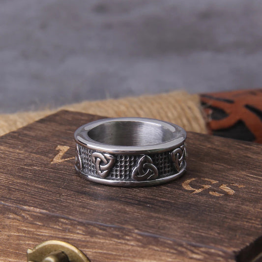 A stainless steel ring engraved with Triquetra symbols, representing the eternal Celtic knot, showcasing the intricate design and craftsmanship.