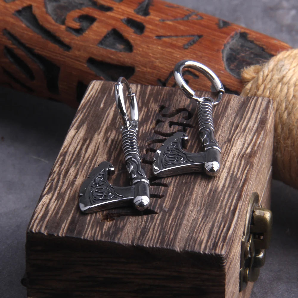 Close-up of battle axe earrings with Celtic art on blades