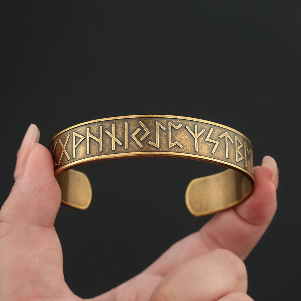 Side view of gold-colored cuff with engraved runes