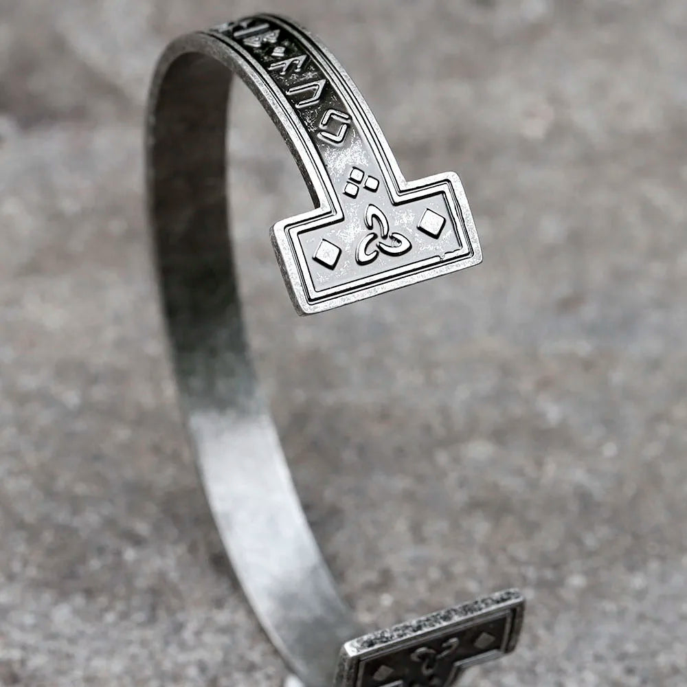 Viking-style adjustable arm ring with runic engraving on its band.