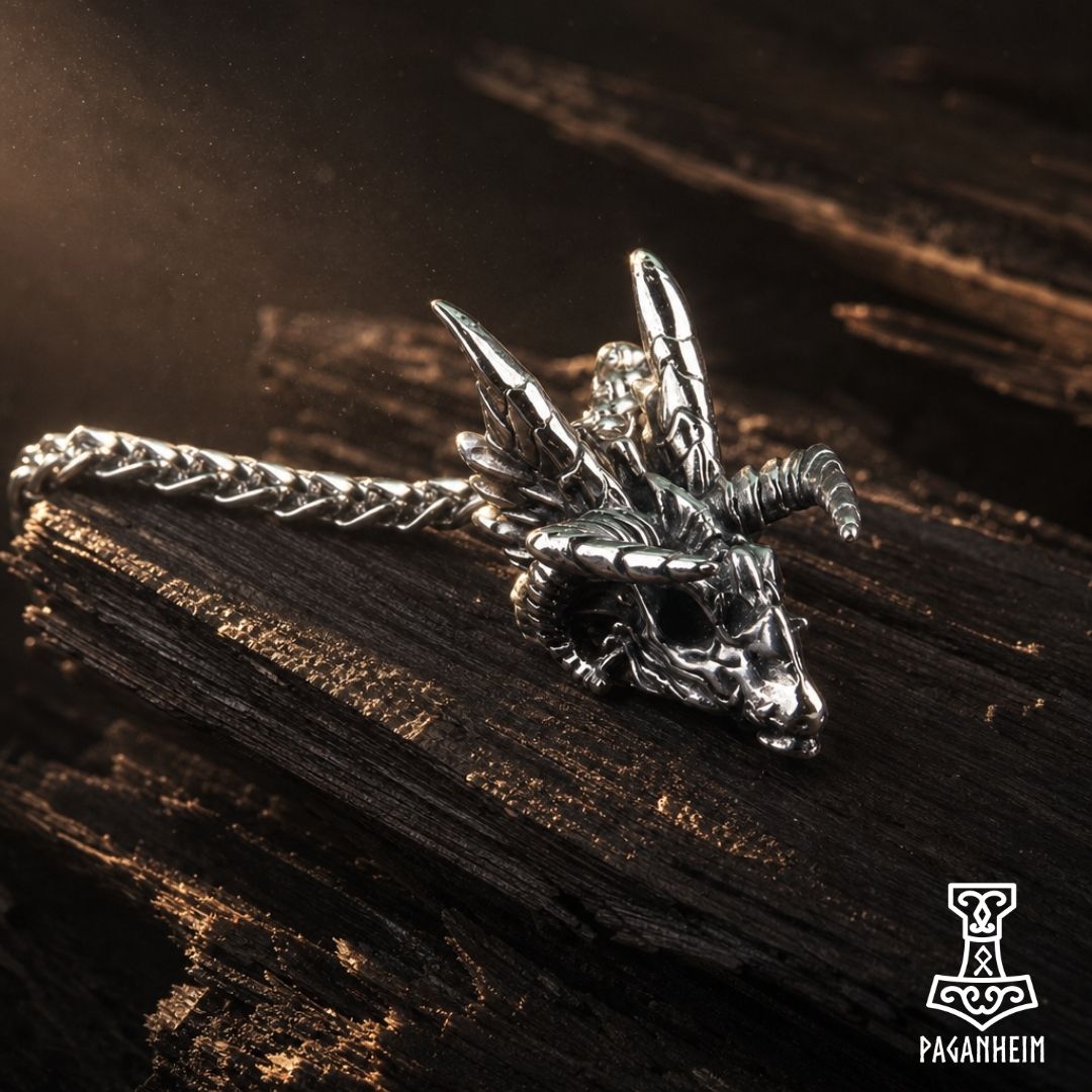 Dragon skull pendant with four pairs of horns resting on dark wood