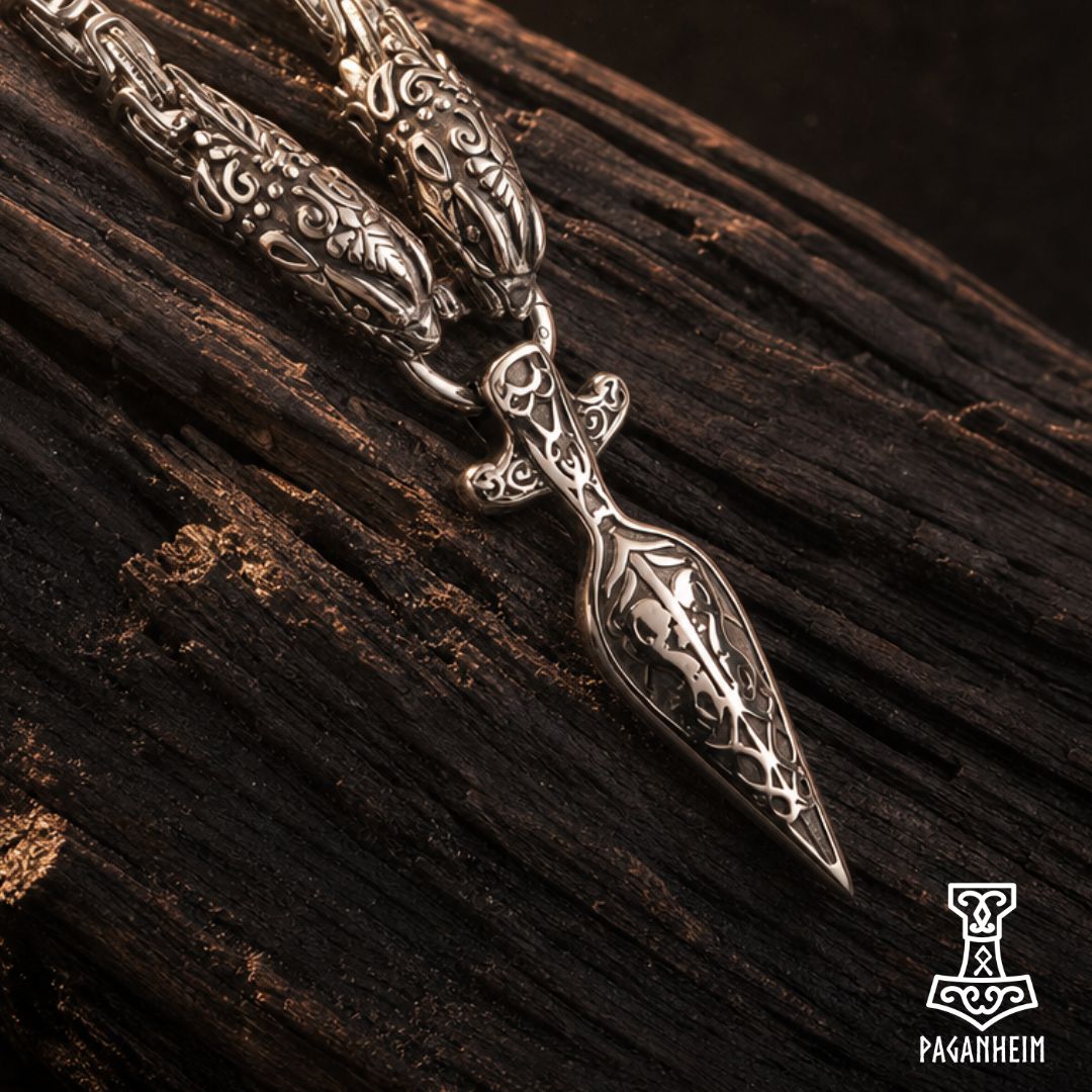 Norse spearhead necklace resting on wooden surface under warm light