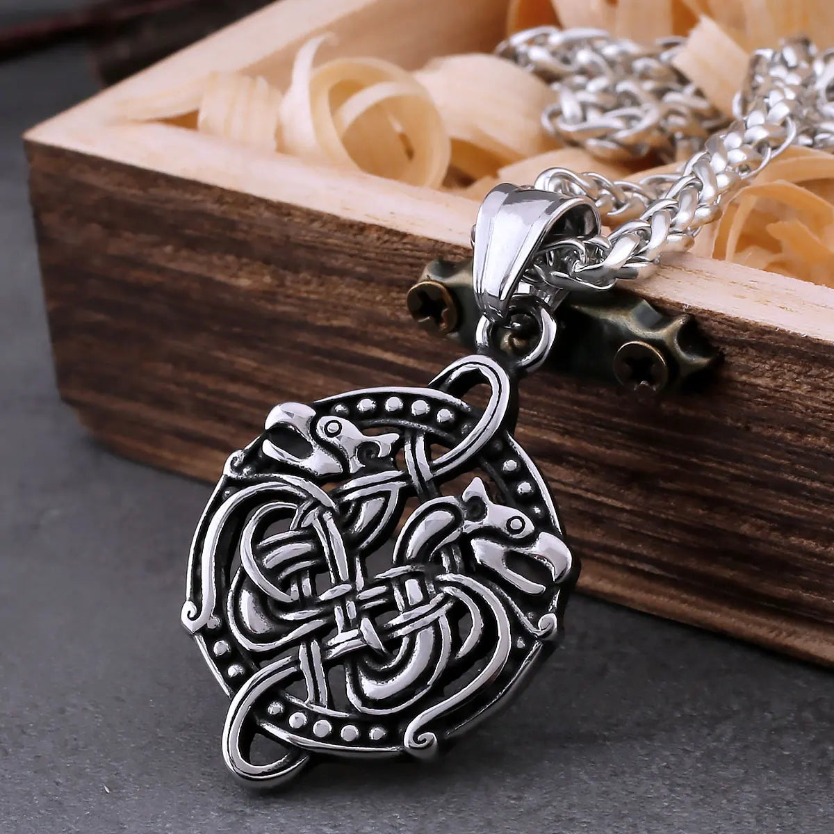 Necklace pendant with two intertwined dragon heads in Old Norse Jelling art style.