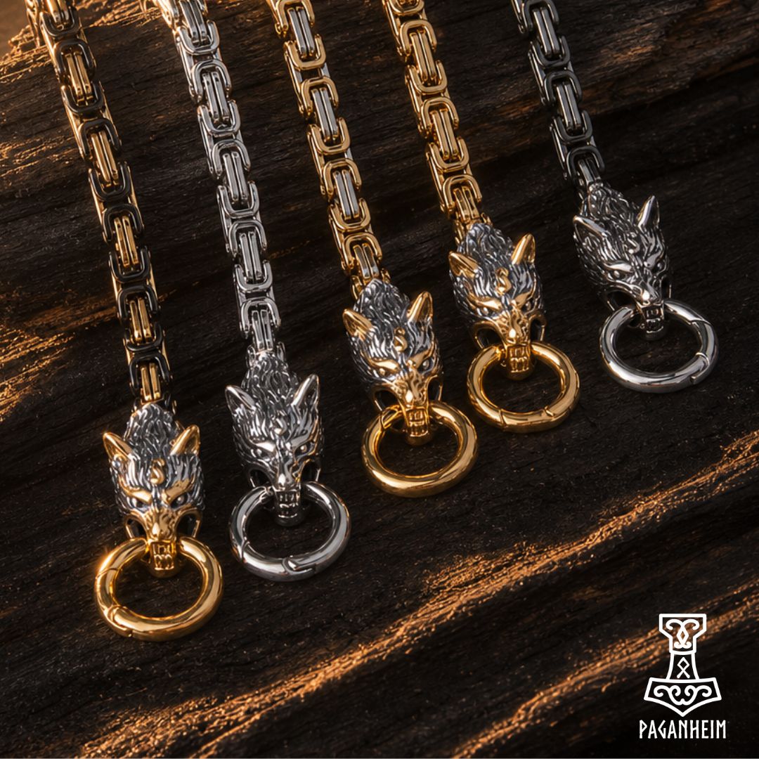 Four Viking-style wolf head byzantine chain bracelets, shown in gold and silver finishes on a dark wood background. The wolf heads are detailed and sit on top of split rings.