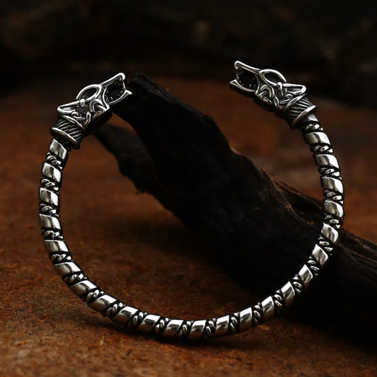 A traditional viking arm ring fashioned with a wolf head on either end, inspired by the sons of Fenrir, Skoll and Hati