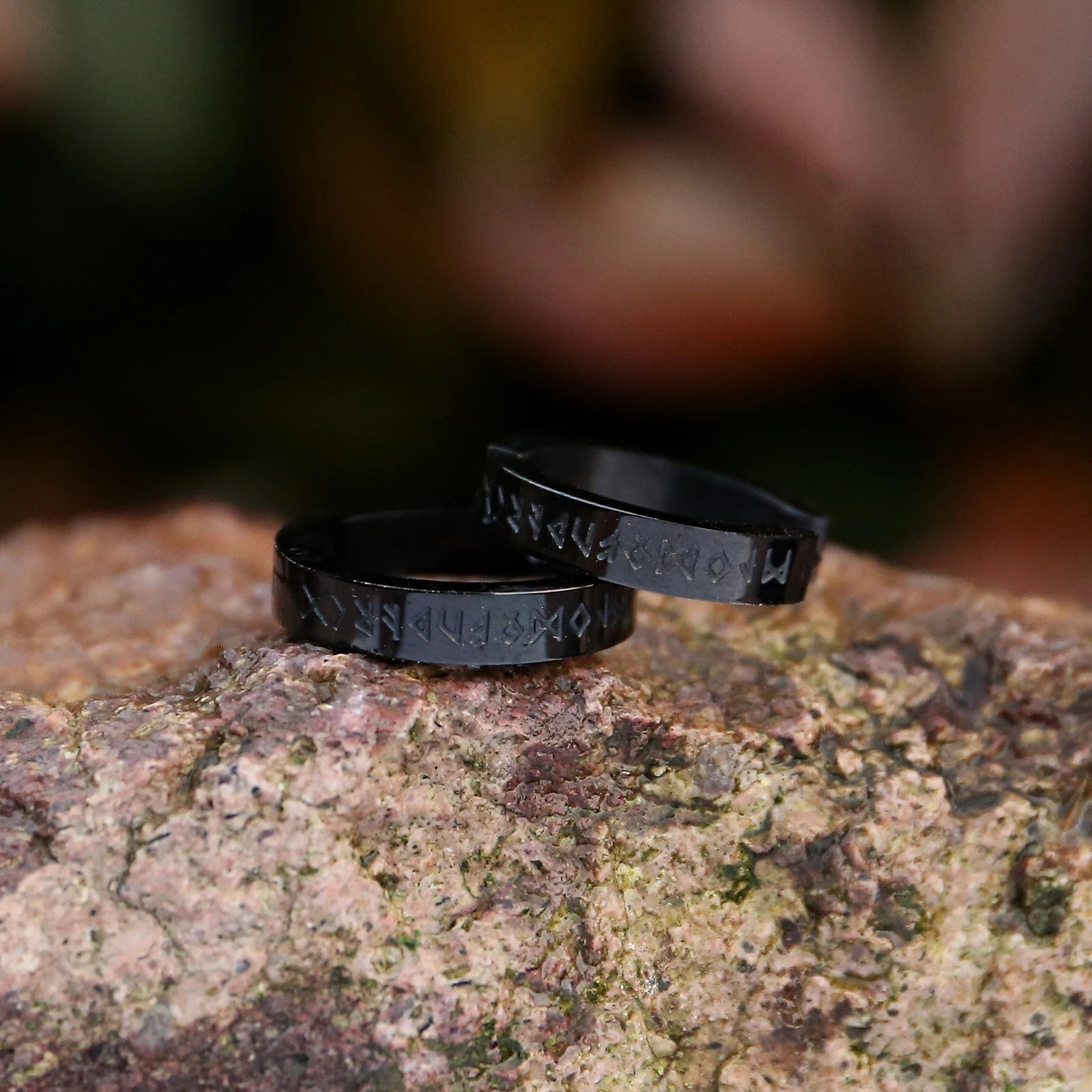 Close-up of black Elder Futhark rune earrings inspired by Norse culture.