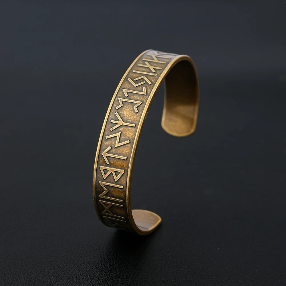 Detailed view of engraved Norse runes on gold bangle