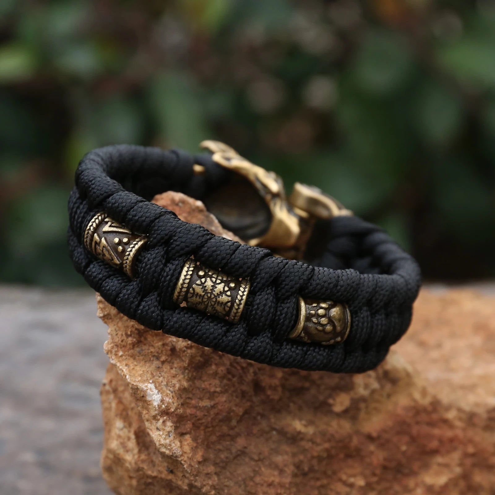 Paracord bracelet with Valknut, Helm of Awe, and bear claw symbols.