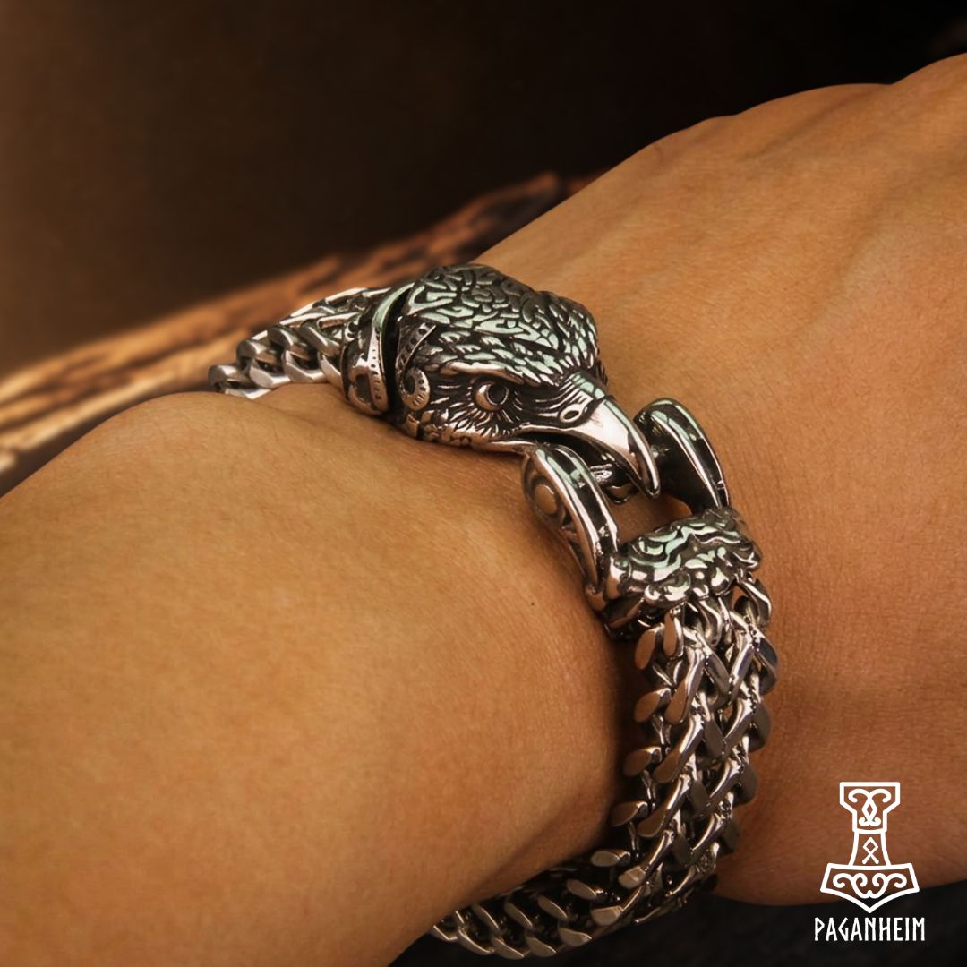 A close-up of a silver-toned Viking eagle head chain bracelet worn on a person's wrist.