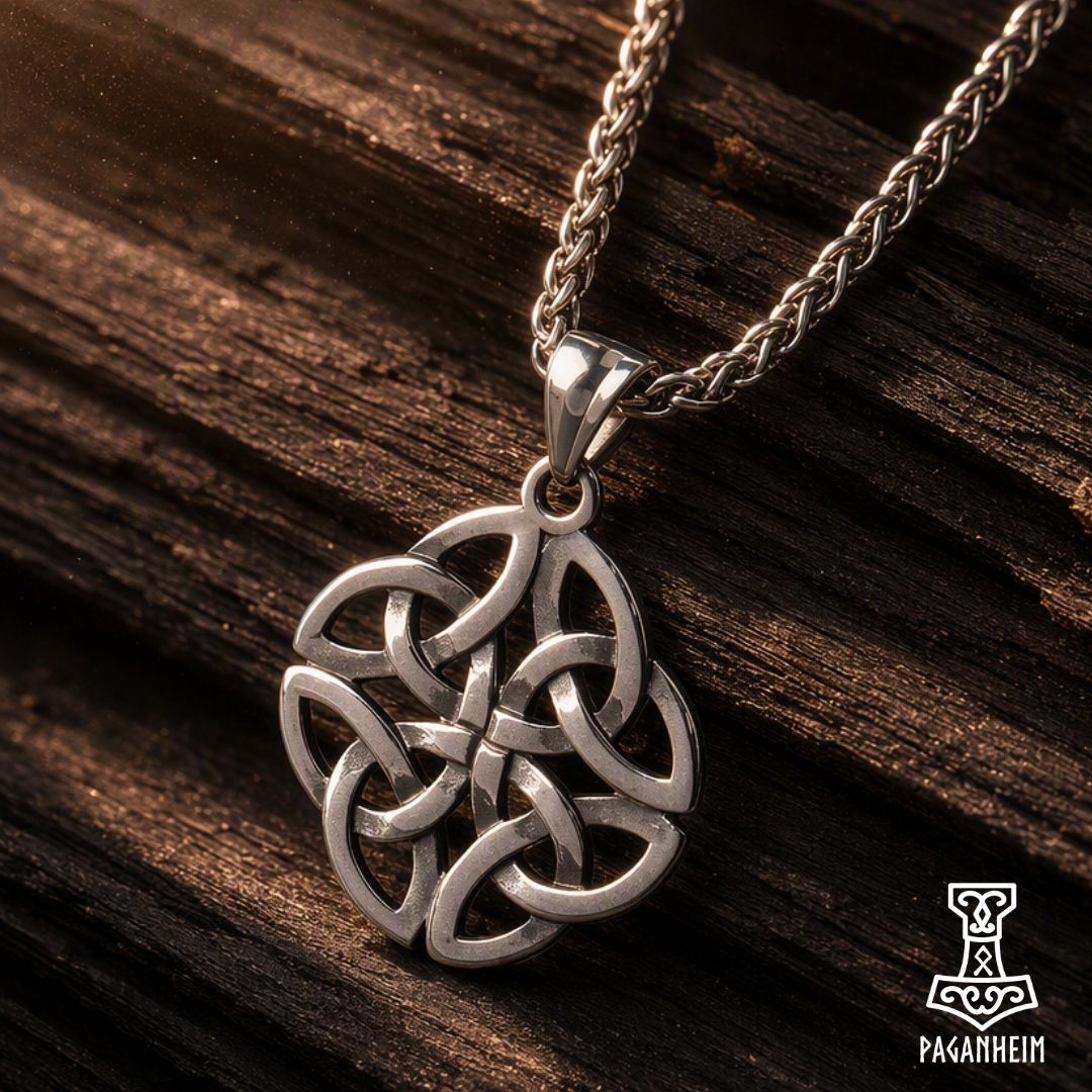 A silver-toned Celtic knotwork pendant necklace on a braided chain, displayed on a dark textured wooden surface.