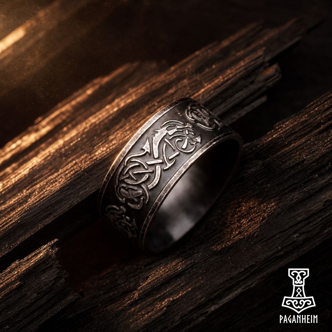 Closeup of aged Germanic metal ring showing intricate Norse animal patterns in the Jelling style.