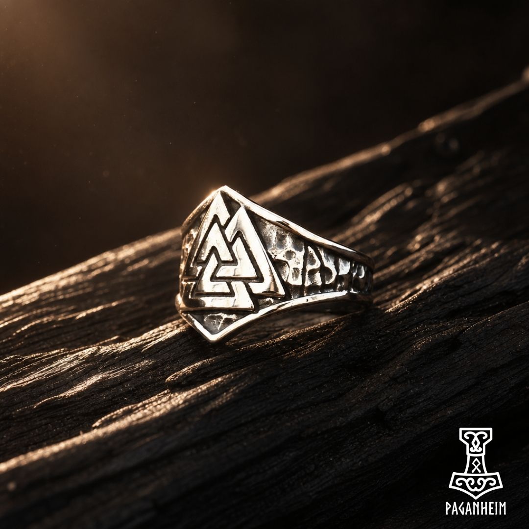 Valknut crown ring resting on wooden surface