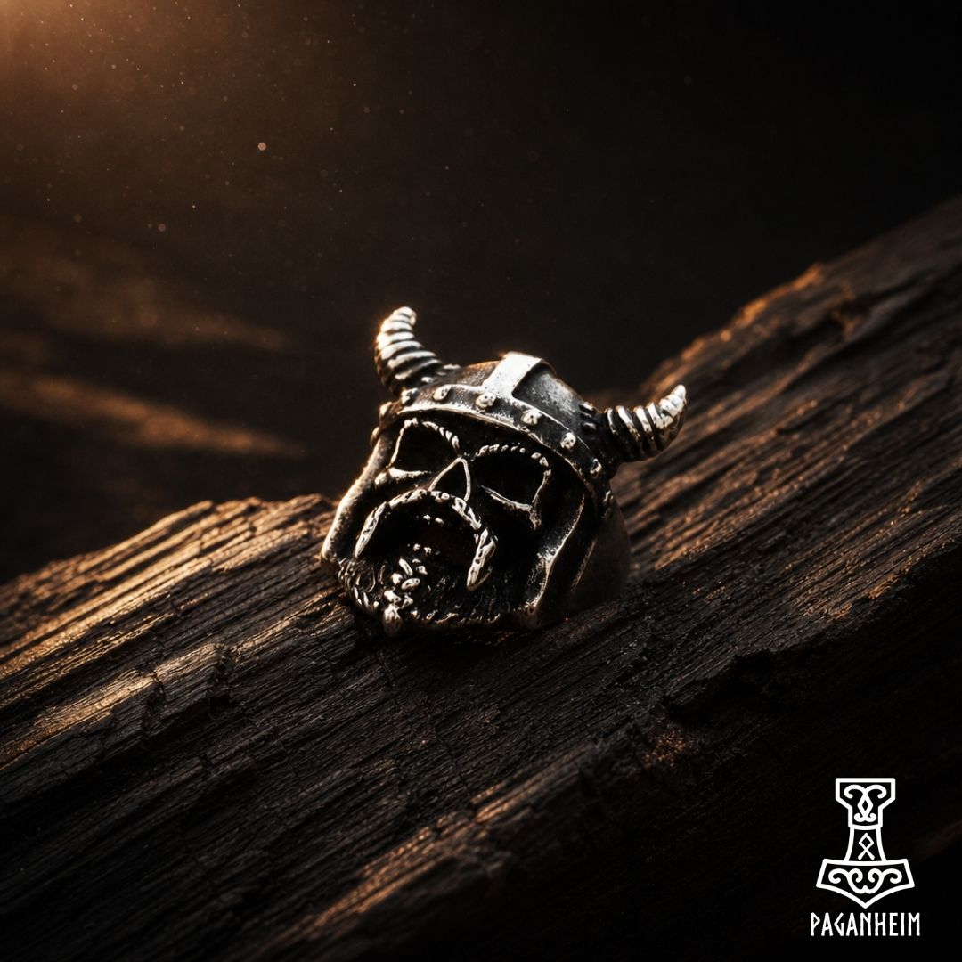 Viking skull ring resting on dark wood surface with aged finish