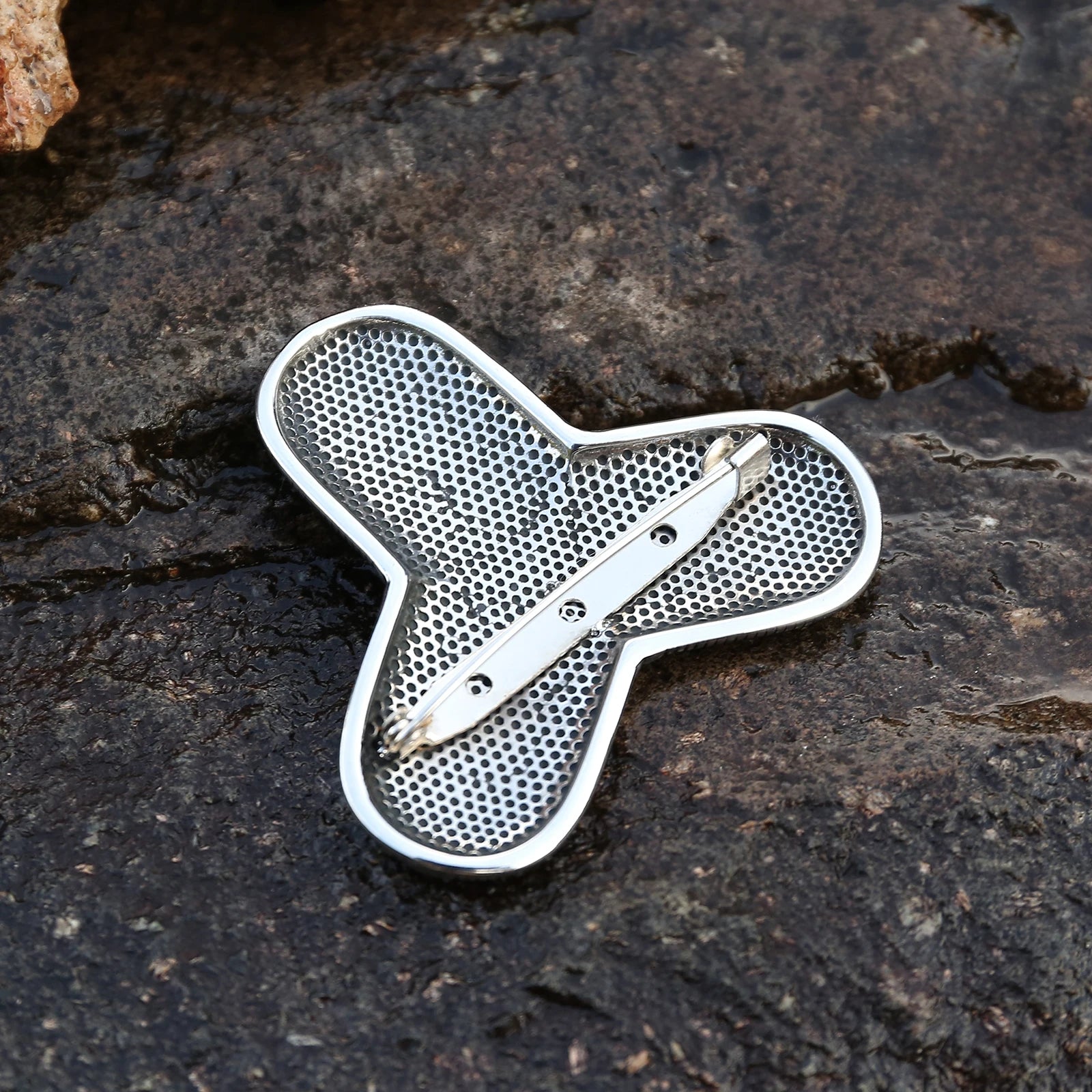 Intricate Jelling art style brooch inspired by Viking culture.