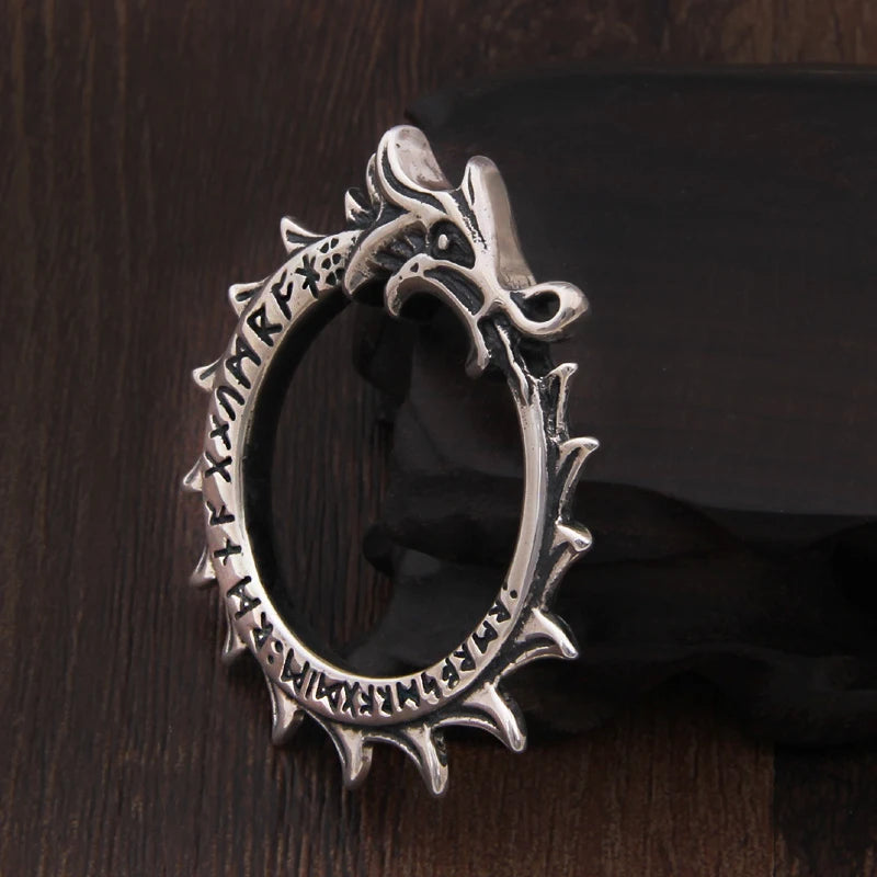 Silver ouroboros pendant with runic engravings and serpent design.