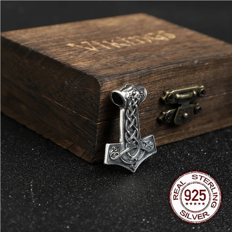 A close-up of a sterling silver Mjölnir amulet inspired by the Jelling Stones.