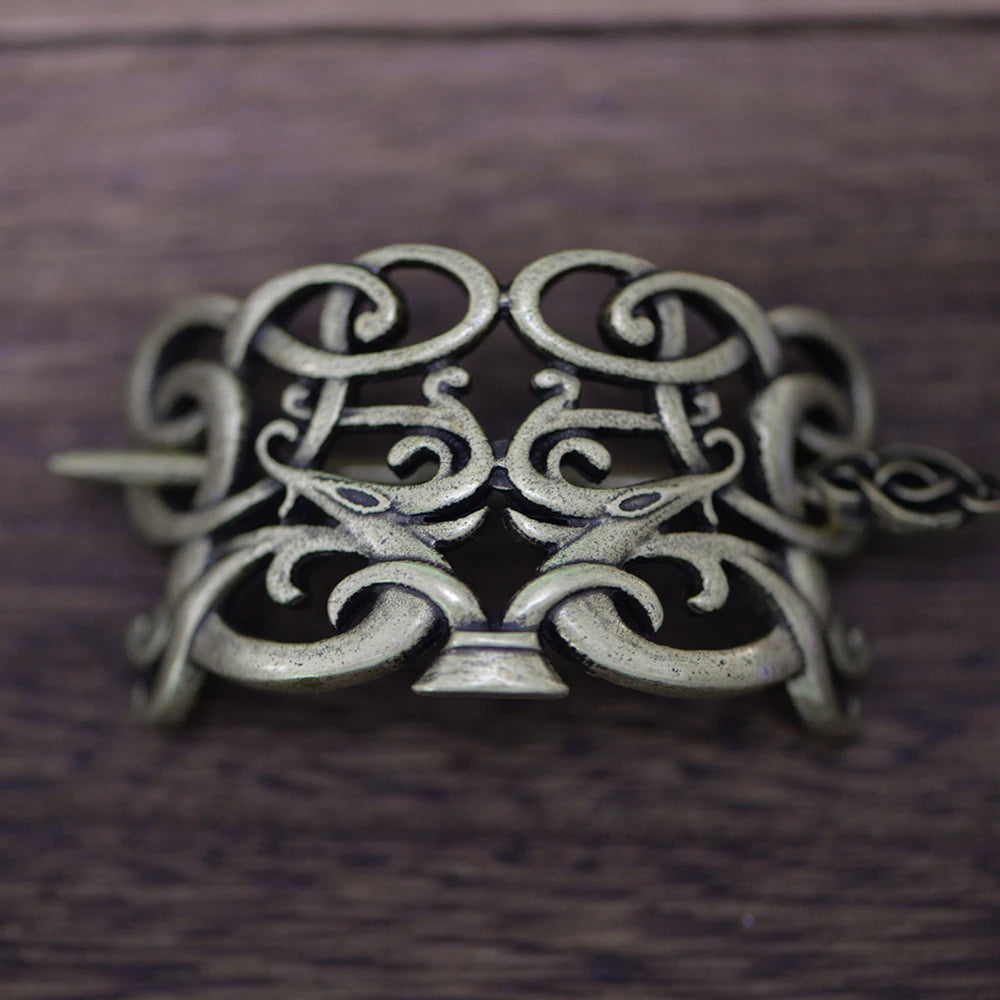 Viking hair brooch with intricate Jelling motifs and ribbon-shaped animal forms.