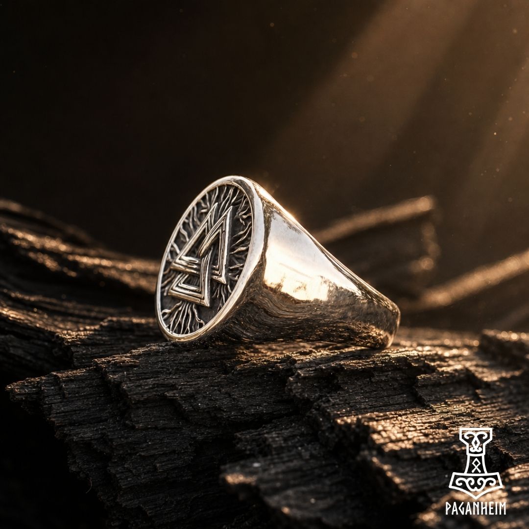 Norse Valknut ring resting on dark wooden surface