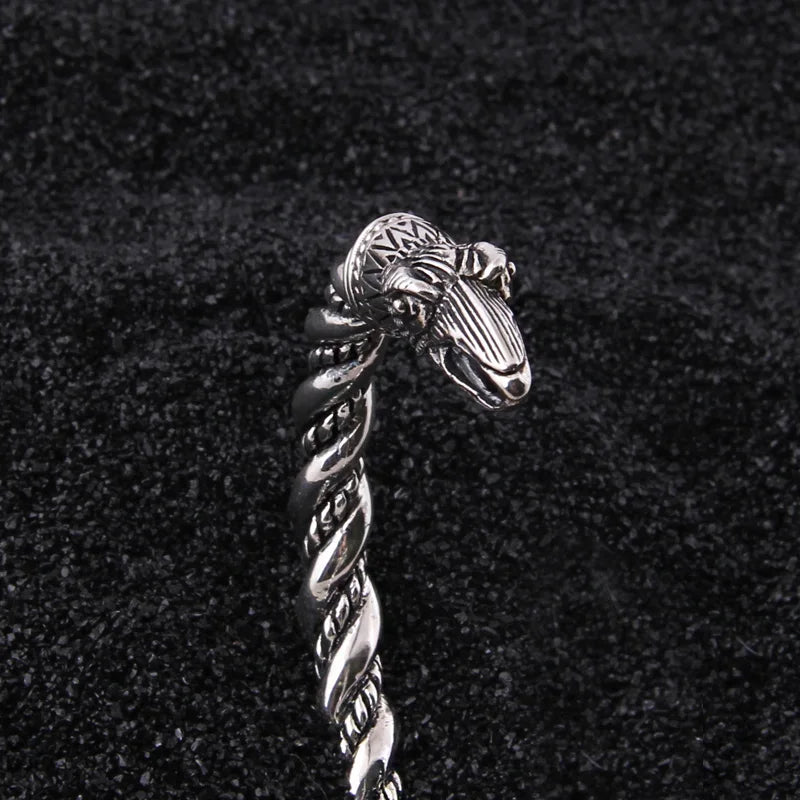 Scandinavian-style twisted rod arm ring with raven heads, crafted in sterling silver.