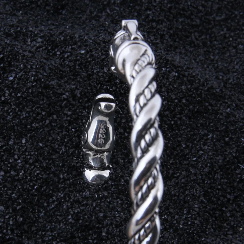 Silver Viking arm ring featuring a rod design and dragon motifs.