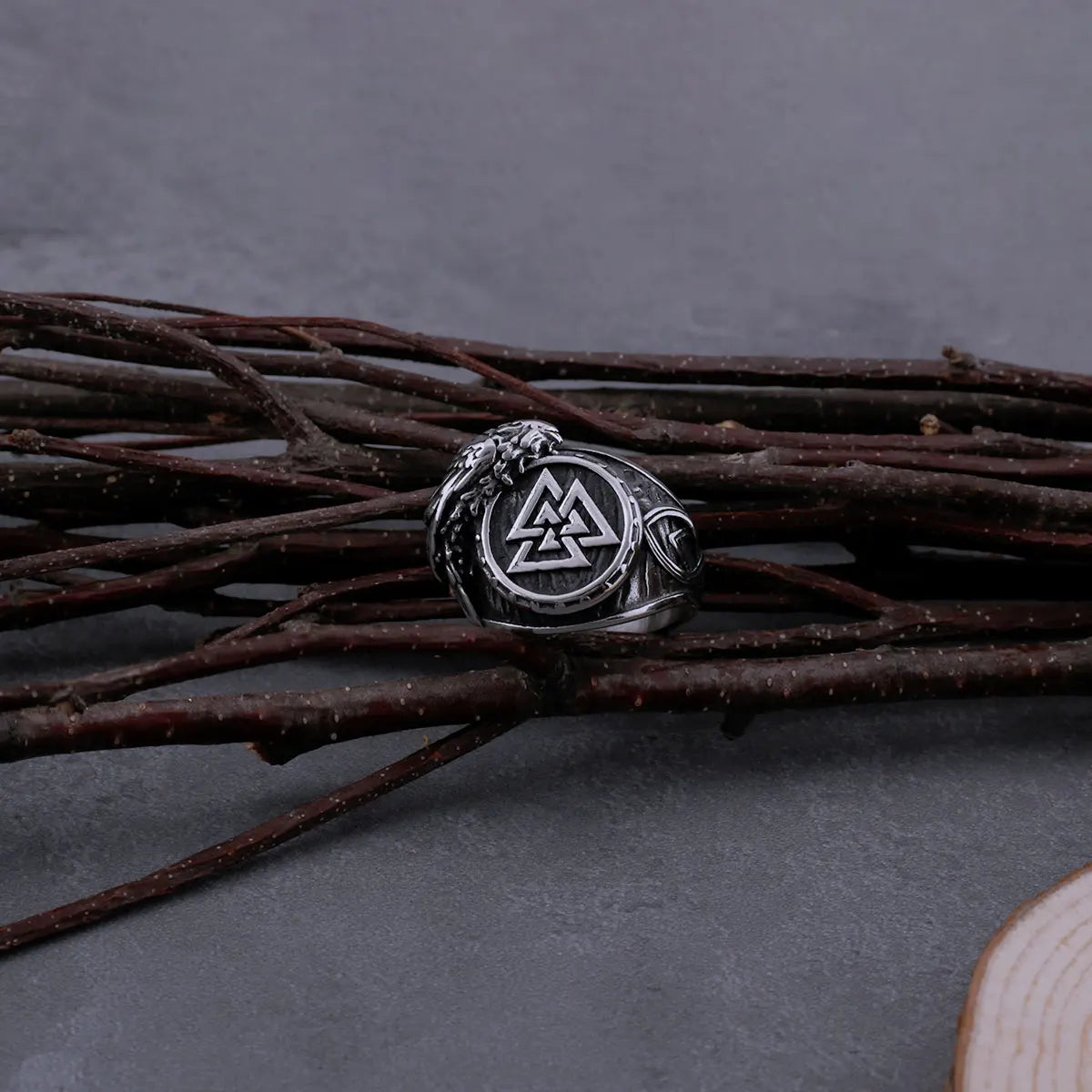 Handcrafted Valknut ring displayed against a rustic background.