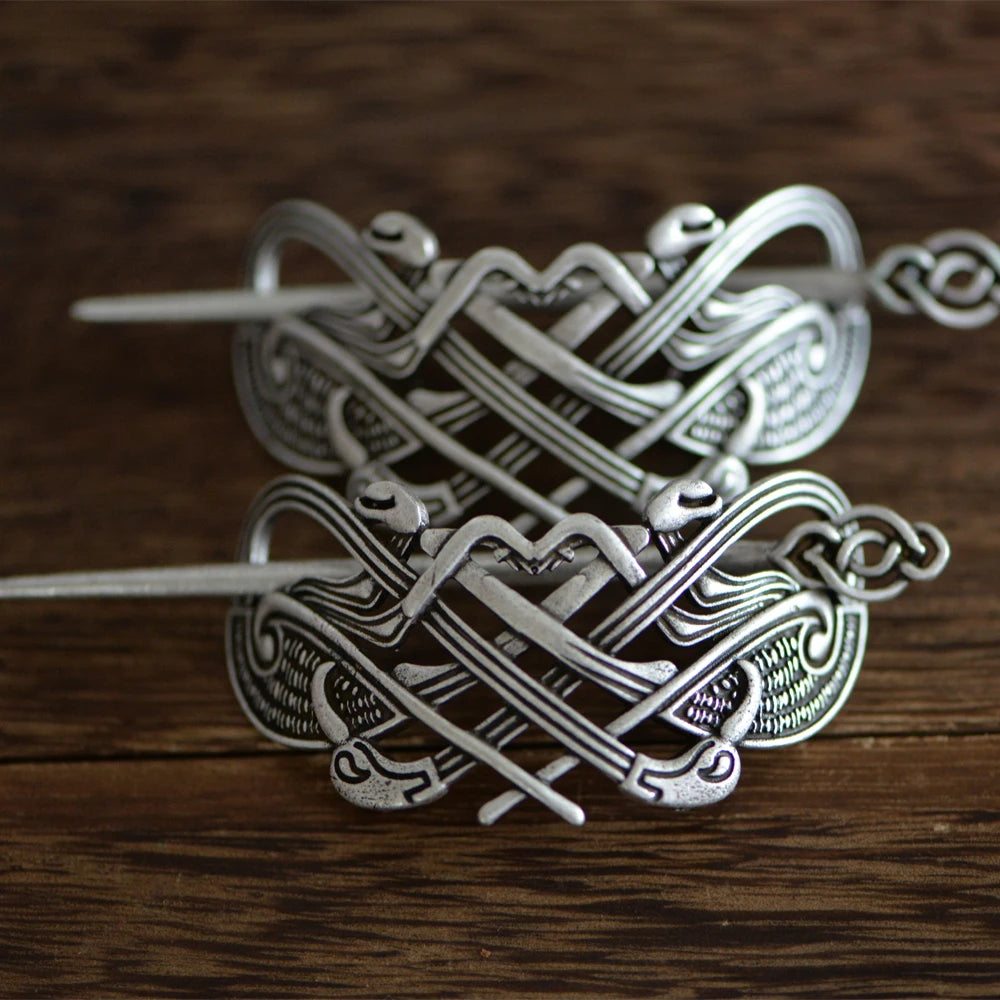 Viking hair pin with intertwined beasts and raven head designs, inspired by Mammen and Ringerike art styles.