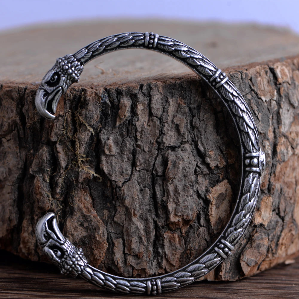 Engraved cuff bracelet featuring Norse-inspired raven feather designs.