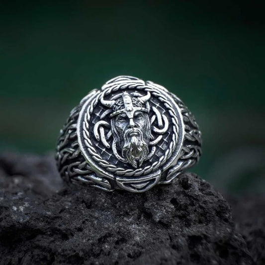 Stainless steel ring featuring an intricately engraved face of a Viking warrior with intersected patterns of the Web of Wyrd symbolizing fate.